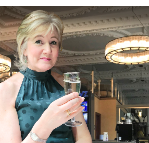 Culture Calendar host Catherine smiling and raising a glass at a women’s social event in Merseyside.
