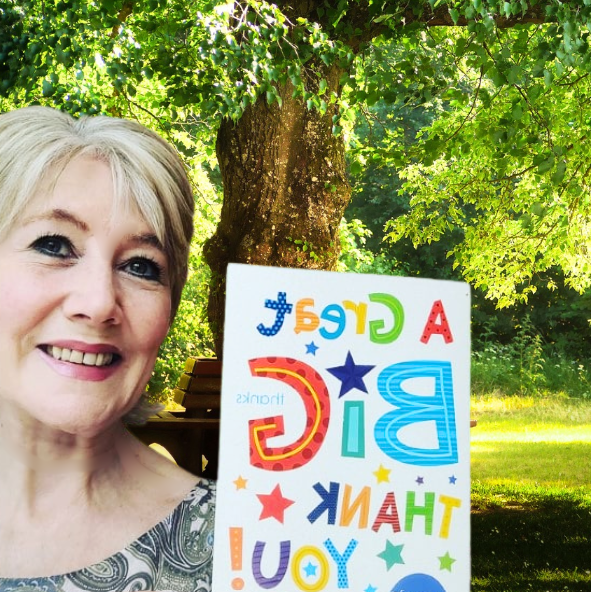 Catherine, founder of Culture Calendar Women’s Social Group in Merseyside and West Lancashire, smiling and holding a thank you card after gifting tulips to a member as a gesture of friendship and appreciation.